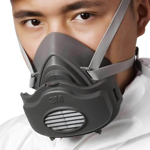 Man wearing 3M Single Cartridge Half Facepiece Respirator 3200 with elastomeric face seal for automotive and maintenance work.