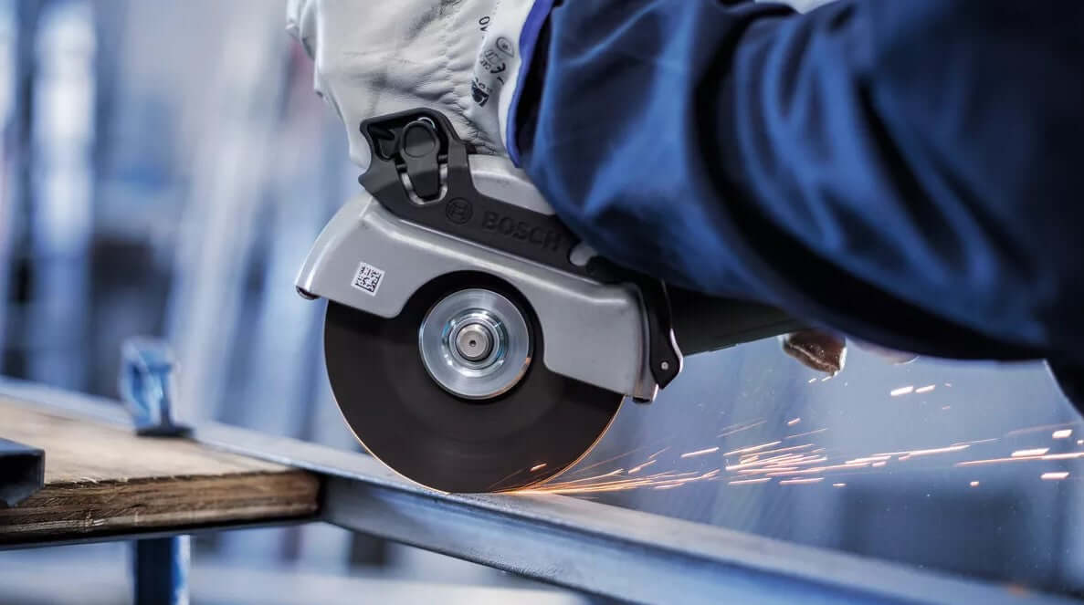 Person using Bosch Pro Cutting Disc on metal with angle grinder, producing sparks, showcasing precision and thin design.