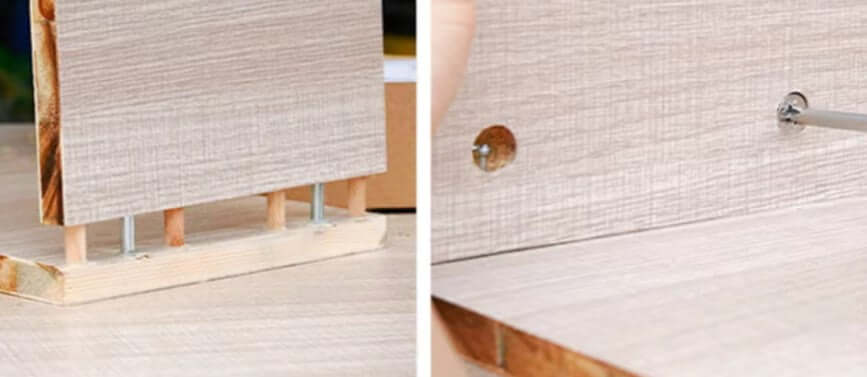 Close-up of a woodworking doweling jig setup showing a wooden panel and metal fasteners for precise drilling.