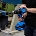 Kincrome cordless drill being used by a person in a workshop setting, showcasing power tool precision and design.